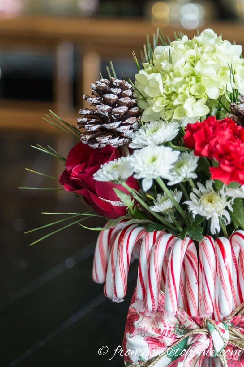 Add evergreen sprigs and pine cone picks | Add some holiday spirit to your Christmas table decor with this red and white DIY candy cane Christmas centerpiece! | DIY Quick and Easy Candy Cane Christmas Centerpiece