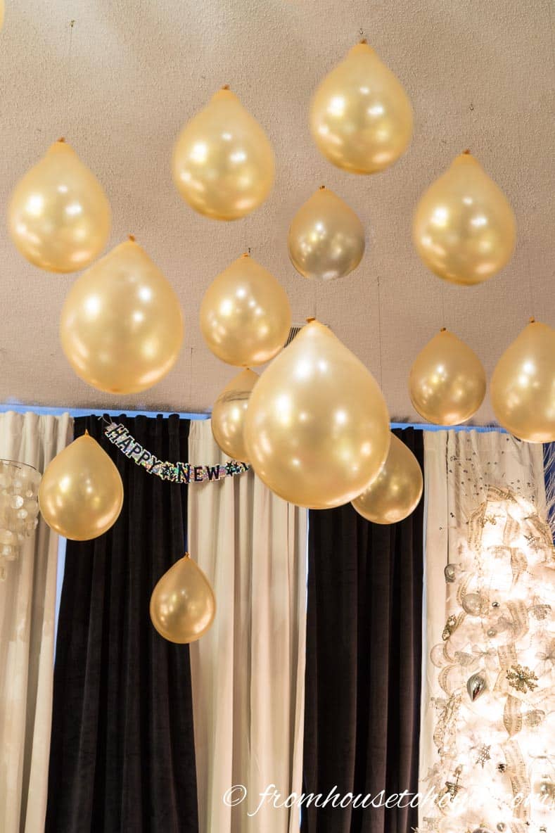 Gold balloons hung from the ceiling are an easy last minute New Year's Eve party decor idea