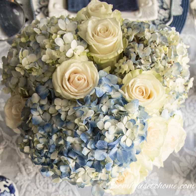 White roses look good with the hydrangeas | Hydrangea-inspired Blue and White Tablescape | If you're looking for Easter dinner or spring table ideas, this blue and white table setting has a hydrangea centerpiece that is perfect for the occasion. The blue and white place setting is really pretty, too.