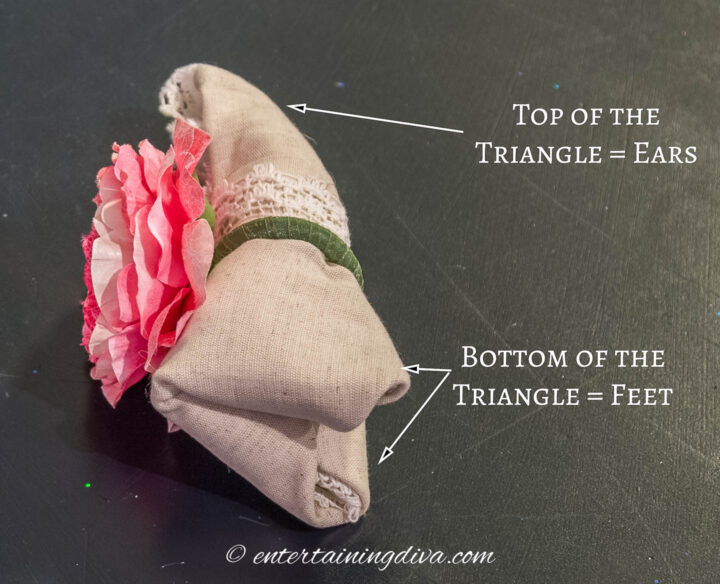 Slip a napkin ring over the top end of the folded napkin