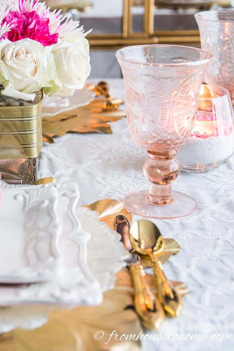 Pink water glass beside a pink and gold place setting