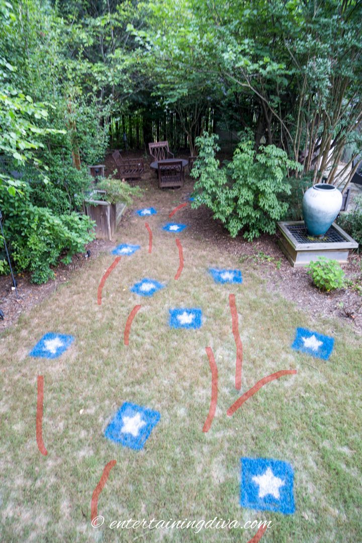 The backyard with red, white and blue stars painted on the grass as 4th of July party decor