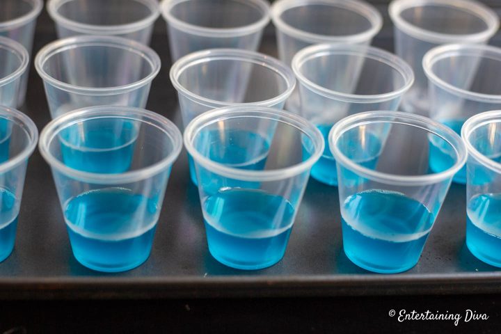 Jello shot cups filled part way with blue jello