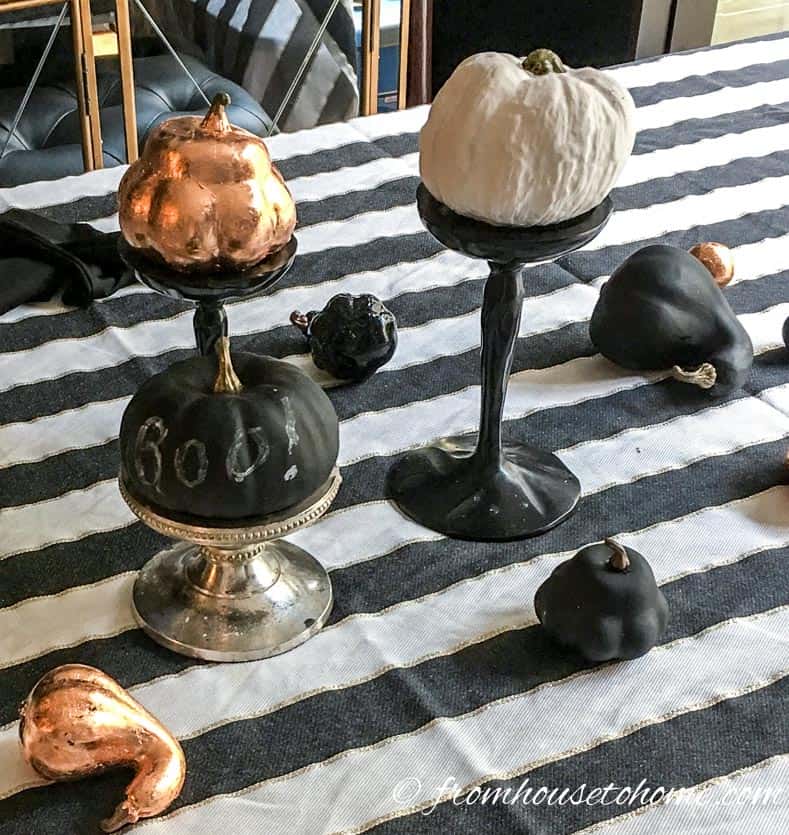 Black, white and copper mini pumpkins on a black and white striped table cloth