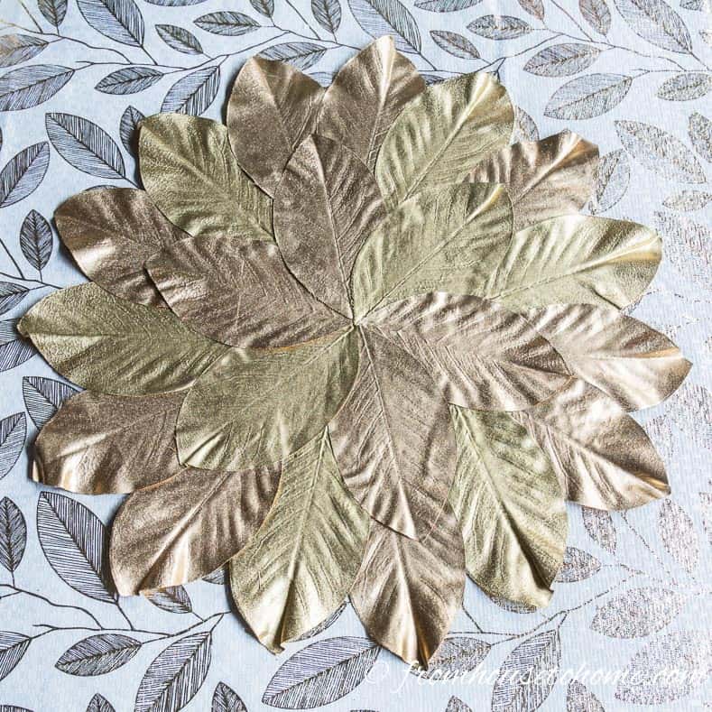 Gold magnolia leaf placemat on white and gold leaf tablecloth