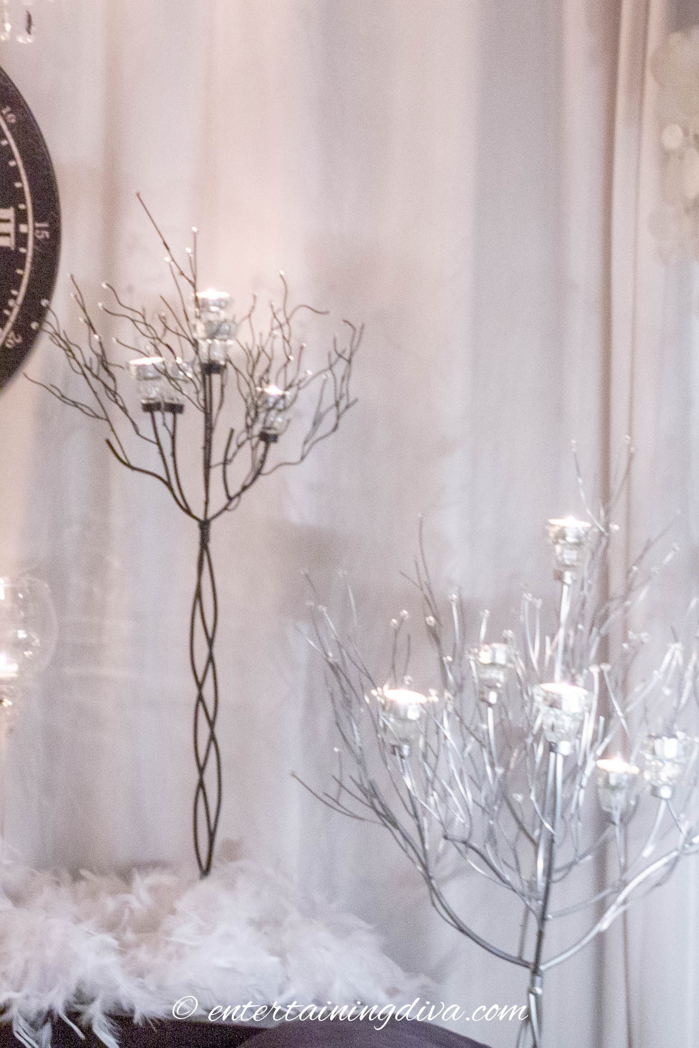 Winter wonderland party decor with candle trees in front of white curtains