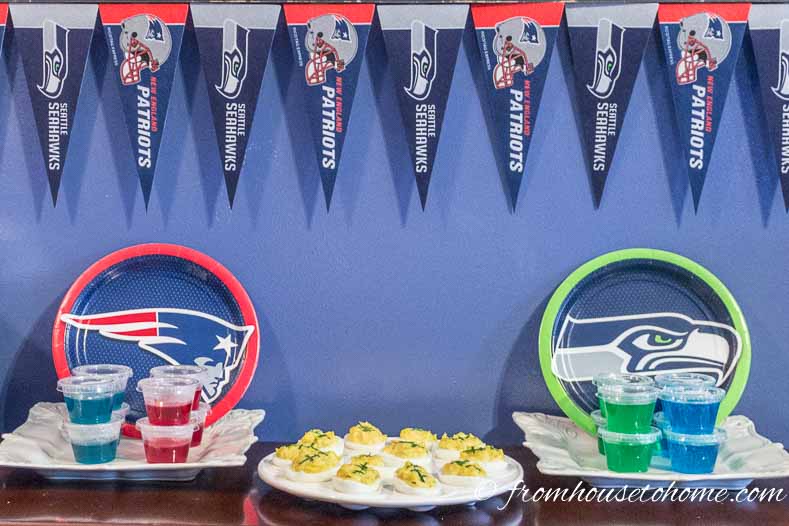 Red and blue jello shots in front of a Patriots paper plate, football deviled eggs, green and blue jello shots in front of a Seahawks paper plate