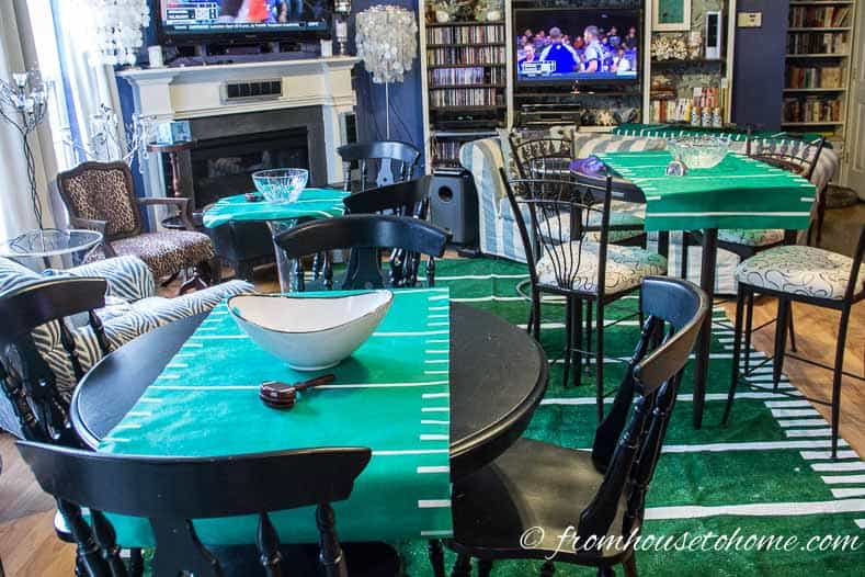 Living room with multiple TV decorated with football field area rug and multiple tables with football field table runners