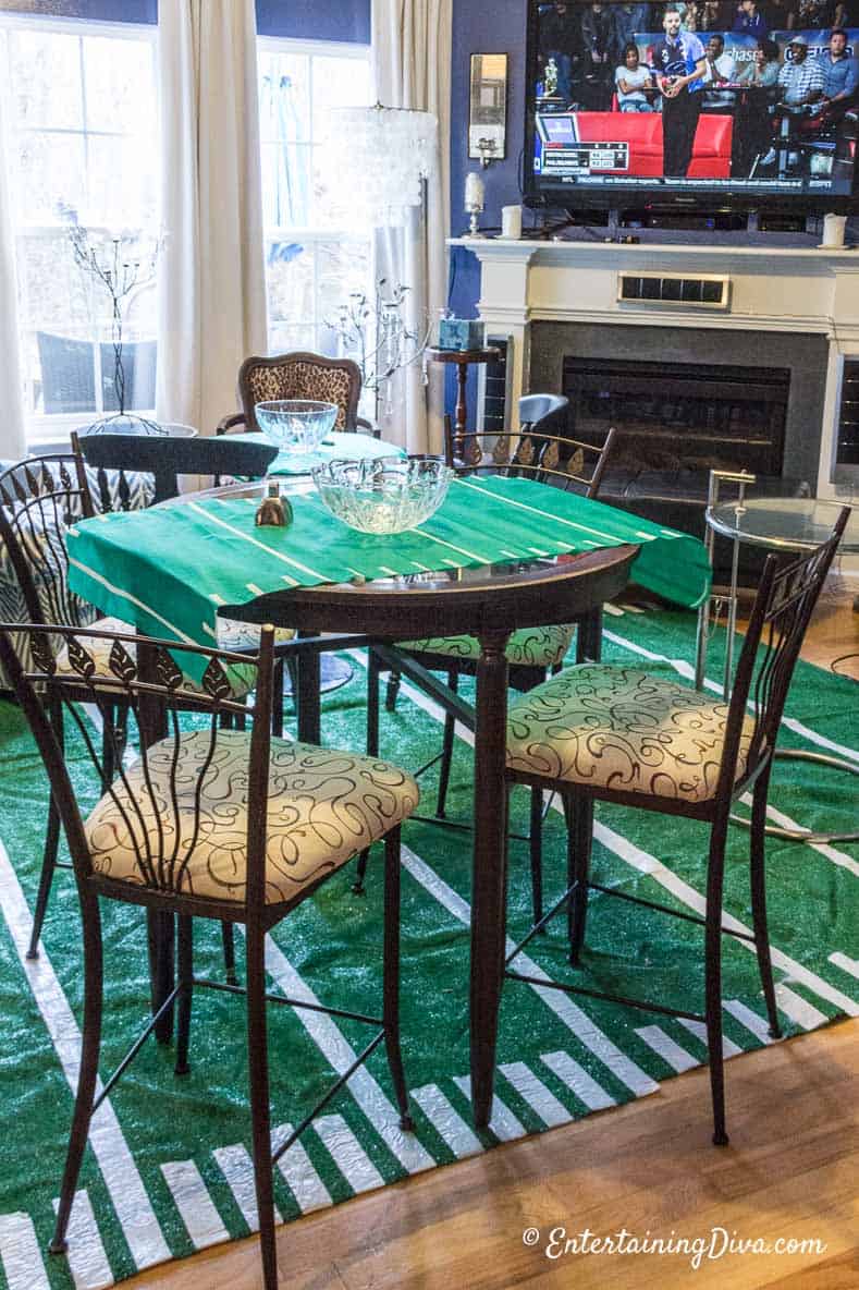 A table with a football field runner in a living room with a football field area rug