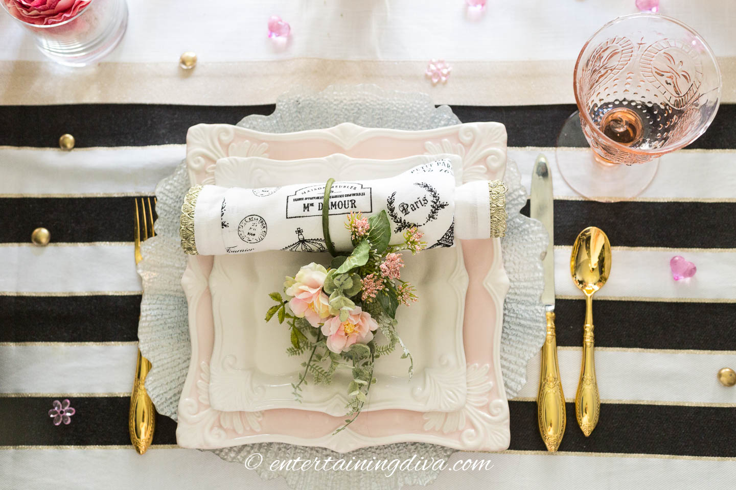 Blush pink place setting with gold cutlery and pink wine glass