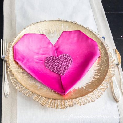 Valentine's Day folded heart napkin on a gold rimmed plate