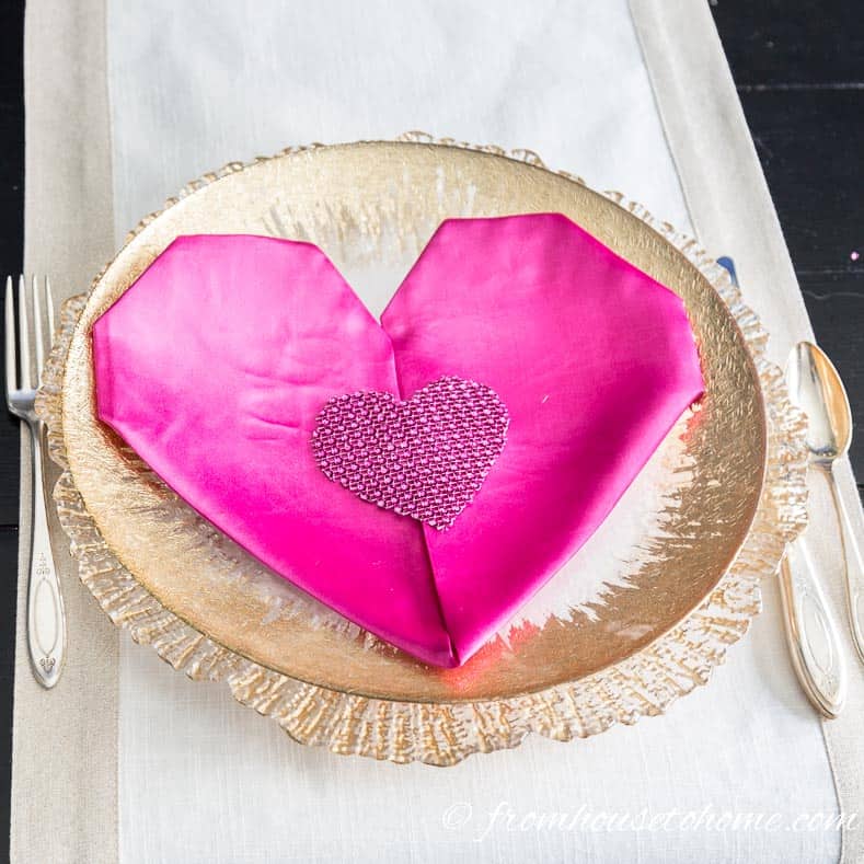 Valentine's Day heart-shaped folded napkin on gold-rimmed plate