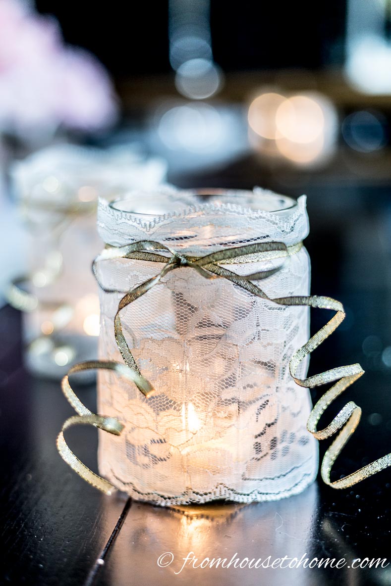 Mason jar wrapped in white lace used as a candleholder