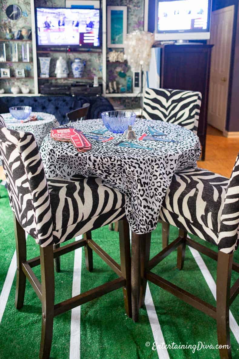 black and white tablecloths and chairs on tables with football decorations