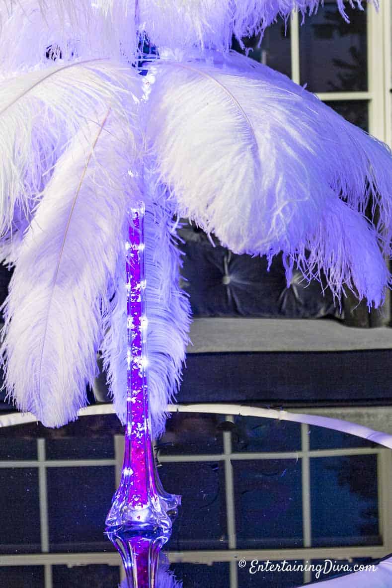 White ostrich feather centerpiece with pink vase filler and pink glimmer lights in the Eiffel tower vase