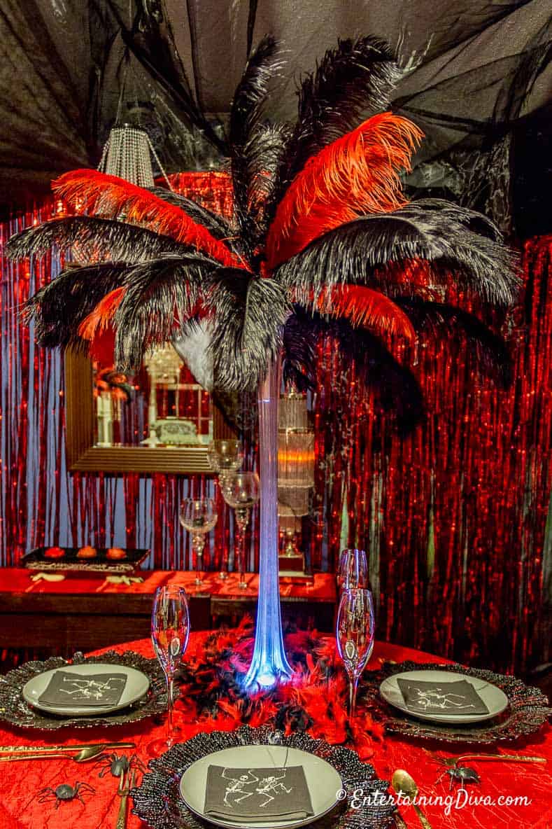 Red and Black Ostrich feather centerpiece on a table set for a Halloween party