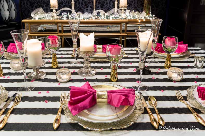 kate spade party decor place setting with white and gold plates, gold cutlery and pink napkins