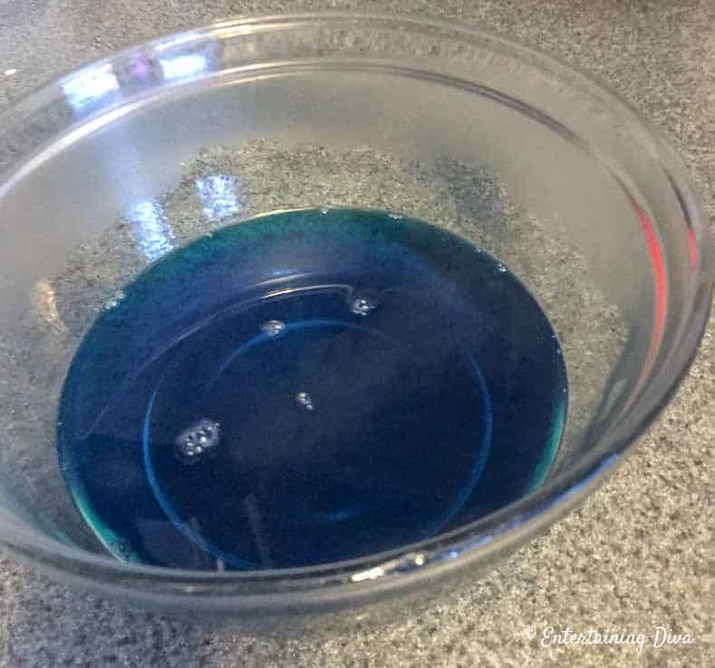 This 'under the sea' Swedish fish jello shot recipe with coconut rum is awesome! It is made with Malibu rum and is one of the best blue jello shots I've tried. #entertainingdiva #jelloshots #cocktailrecipe #summerfun #partyideas Add hot water to the berry blue jello mix