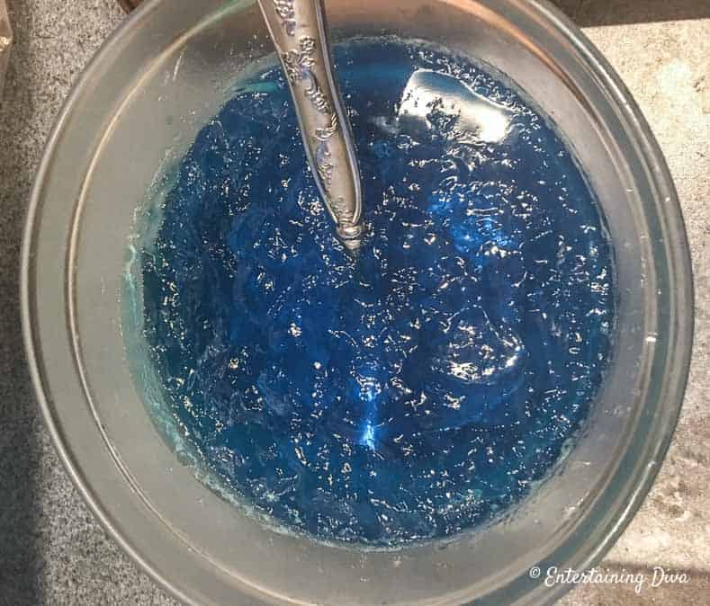 This 'under the sea' Swedish fish jello shot recipe with coconut rum is awesome! It is made with Malibu rum and is one of the best blue jello shots I've tried. #entertainingdiva #jelloshots #cocktailrecipe #summerfun #partyideas Stir the berry blue jello shot mixture