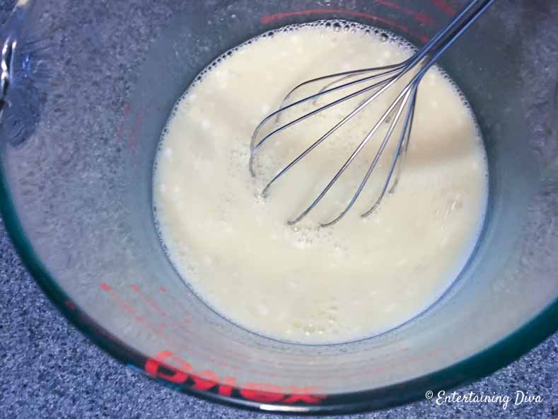 These easy white Pina Colada jello shots are the best! They are made with real pineapple juice, coconut milk and Malibu rum...just like the real drinks. Perfect for summer parties. #EntertainingDiva #summerfun #jelloshots #cocktails #drinks coconut milk, pineapple juice and gelatin in a bowl with a whisk