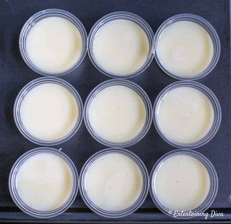 These easy white Pina Colada jello shots are the best! They are made with real pineapple juice, coconut milk and Malibu rum...just like the real drinks. Perfect for summer parties. #EntertainingDiva #summerfun #jelloshots #cocktails #drinks overhead of white pina colada jelly shots in plastic shot cups