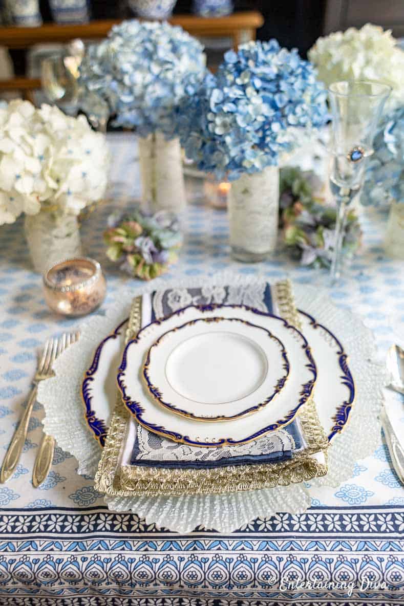 Blue, white and gold napkins on a blue and white place setting