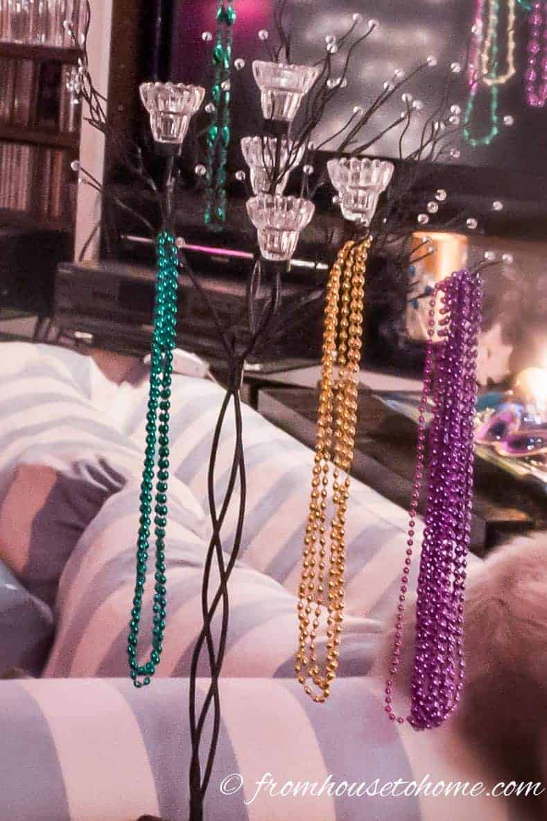 Hang Mardi Gras beads from a candle tree