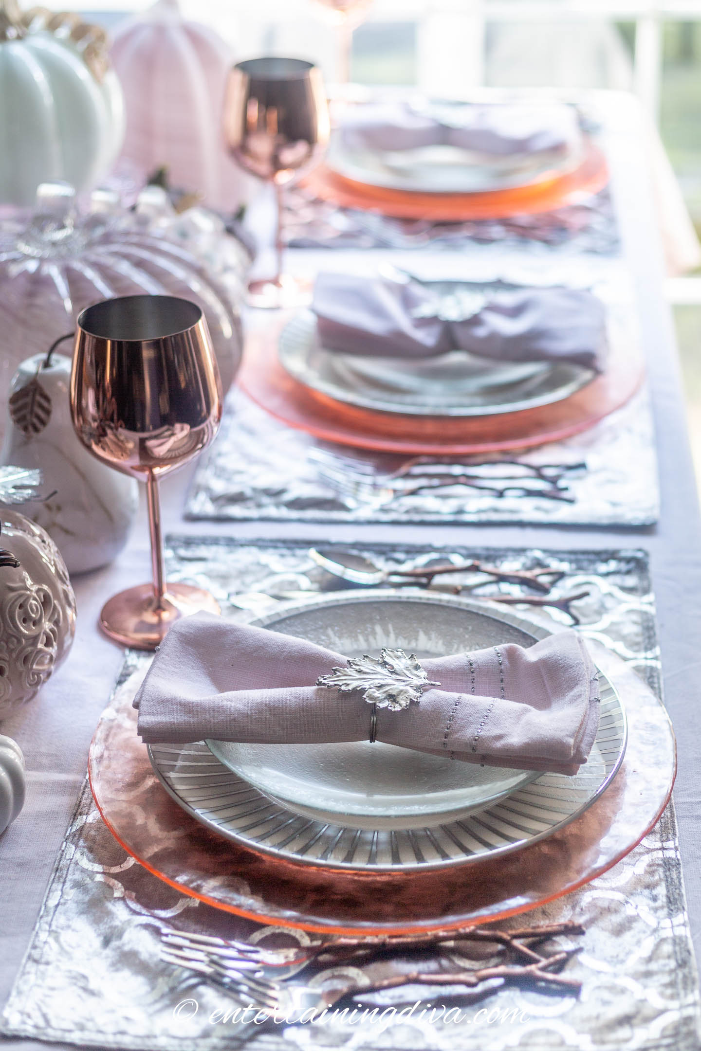 Pink, silver and copper place settings with pink pumpkin centerpiece