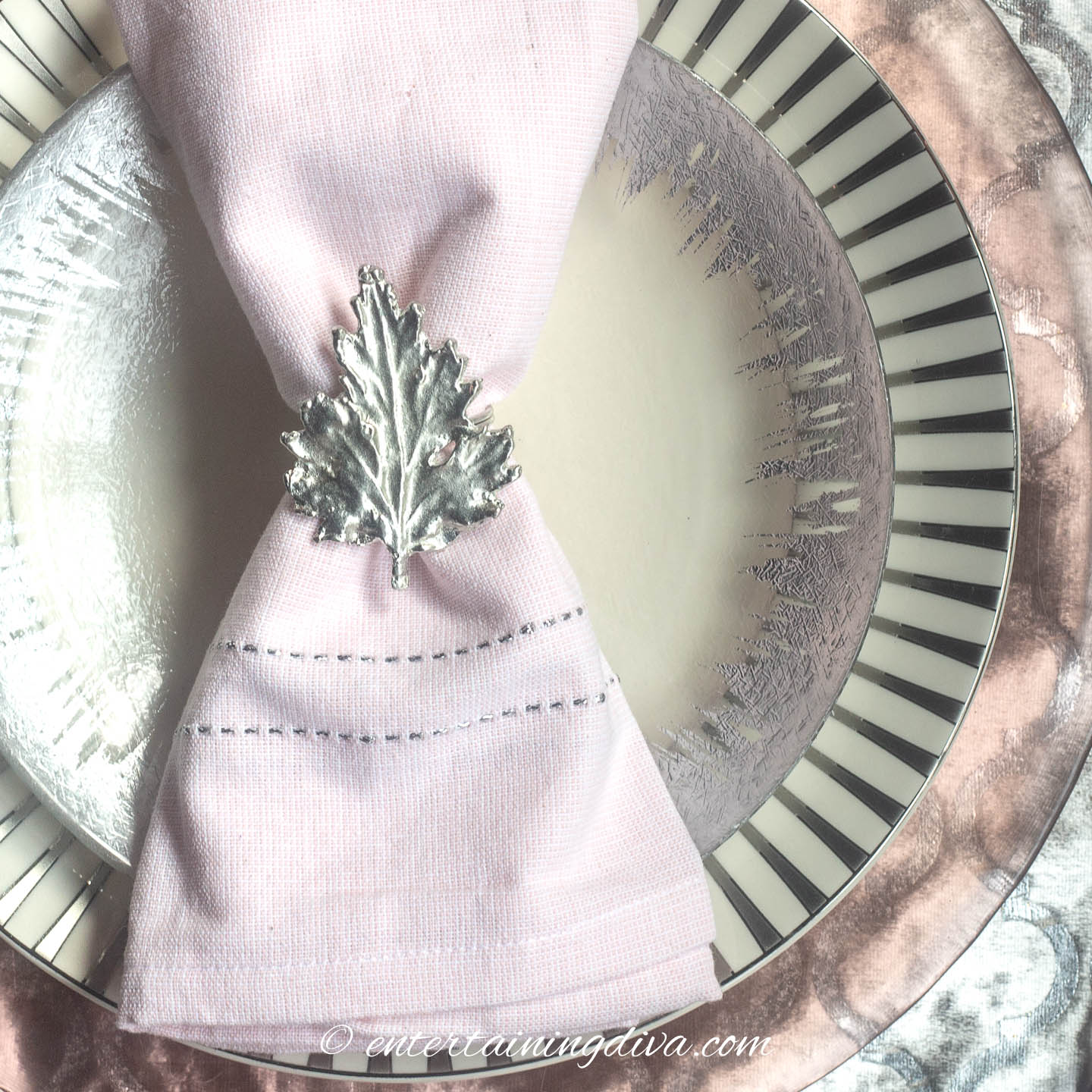Pink and silver place setting with leaf-shaped napkin ring