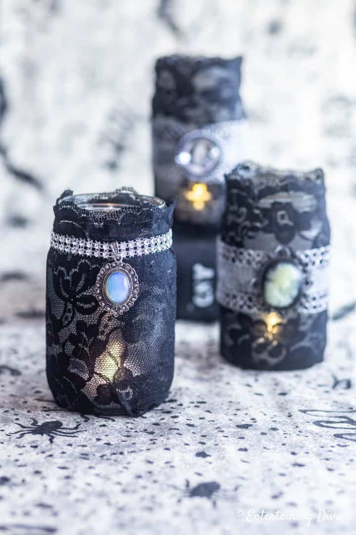 DIY Halloween candle holders made with mason jars, black lace and necklace pendants