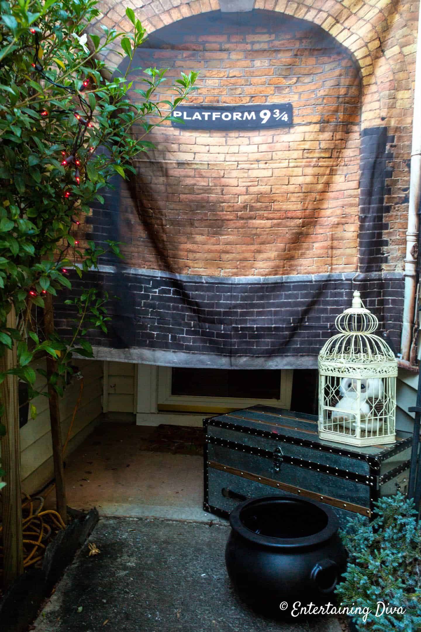 Platform 9 3/4 entrance to a Harry Potter party with trunk and Hedwig owl in a cage