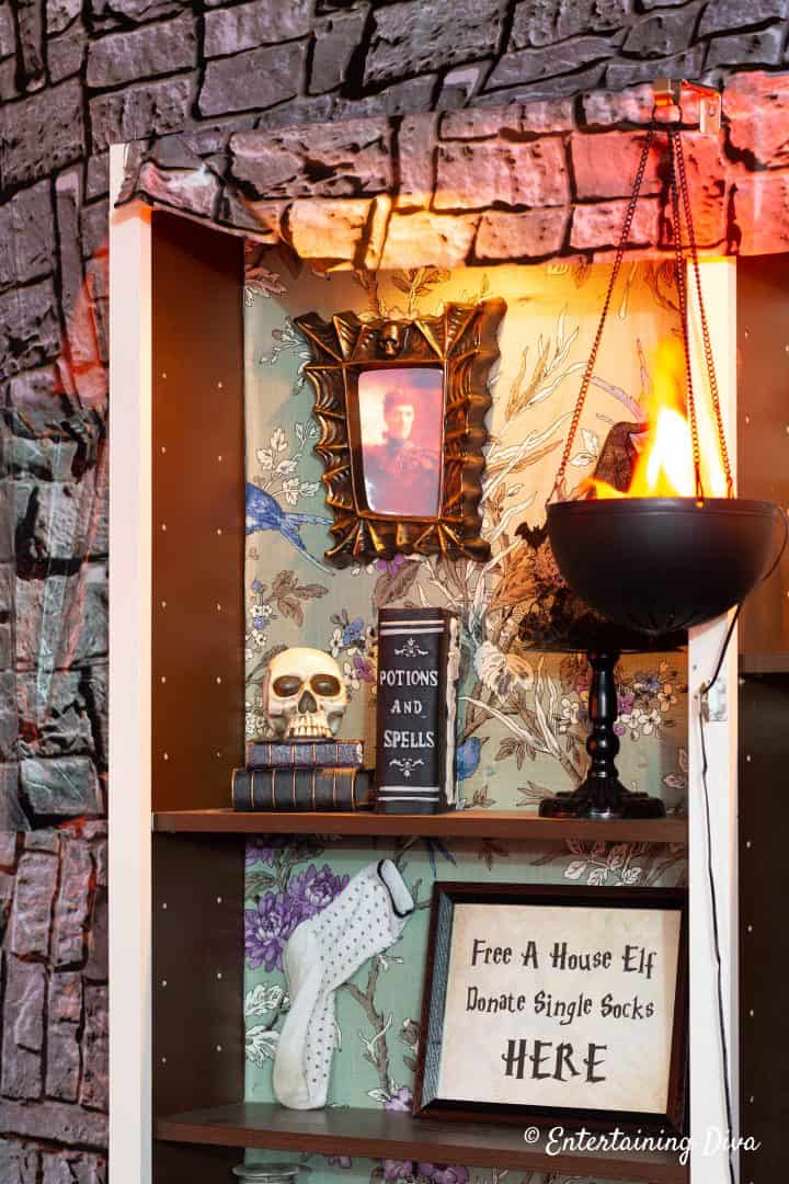 Potion books, hanging flame decoration and Free a House Elf printable sign on a shelf