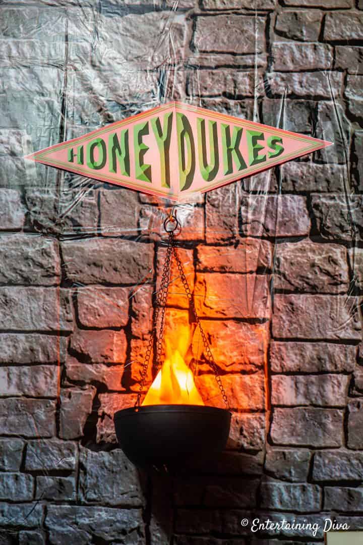 Honeydukes sign with flame decoration hanging under it