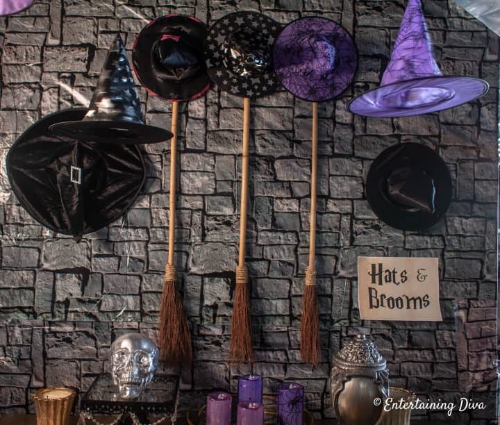Harry Potter party coat check with witch hats and broom sticks on the wall