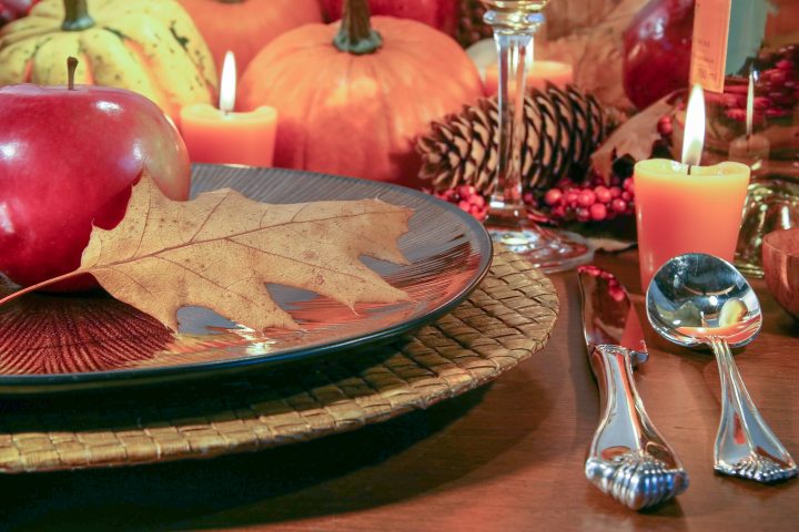 Thanksgiving table with pumpkins, pine cones and apples used as fall decor