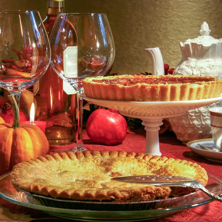 Thanksgiving pies on a table with wine glasses