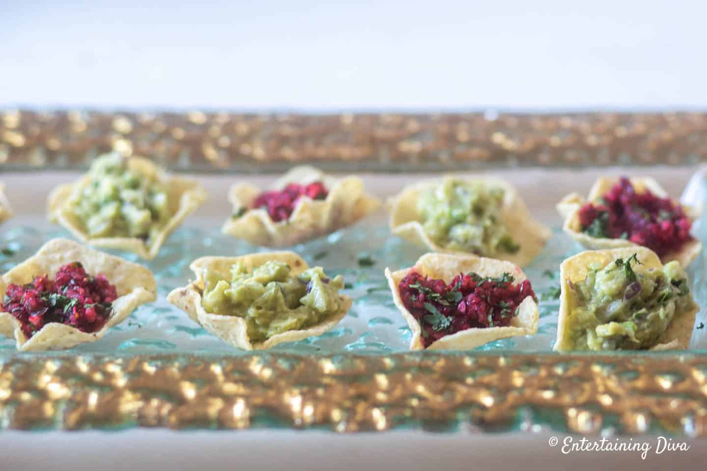 Avocado guacamole dip with tortilla chips and cranberry salsa bites