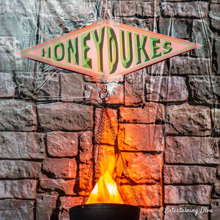 Honeydukes sign taped to a wall above a fake flame