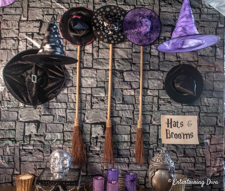 Hats and brooms hung on a wall with the Hats & Brooms printable sign