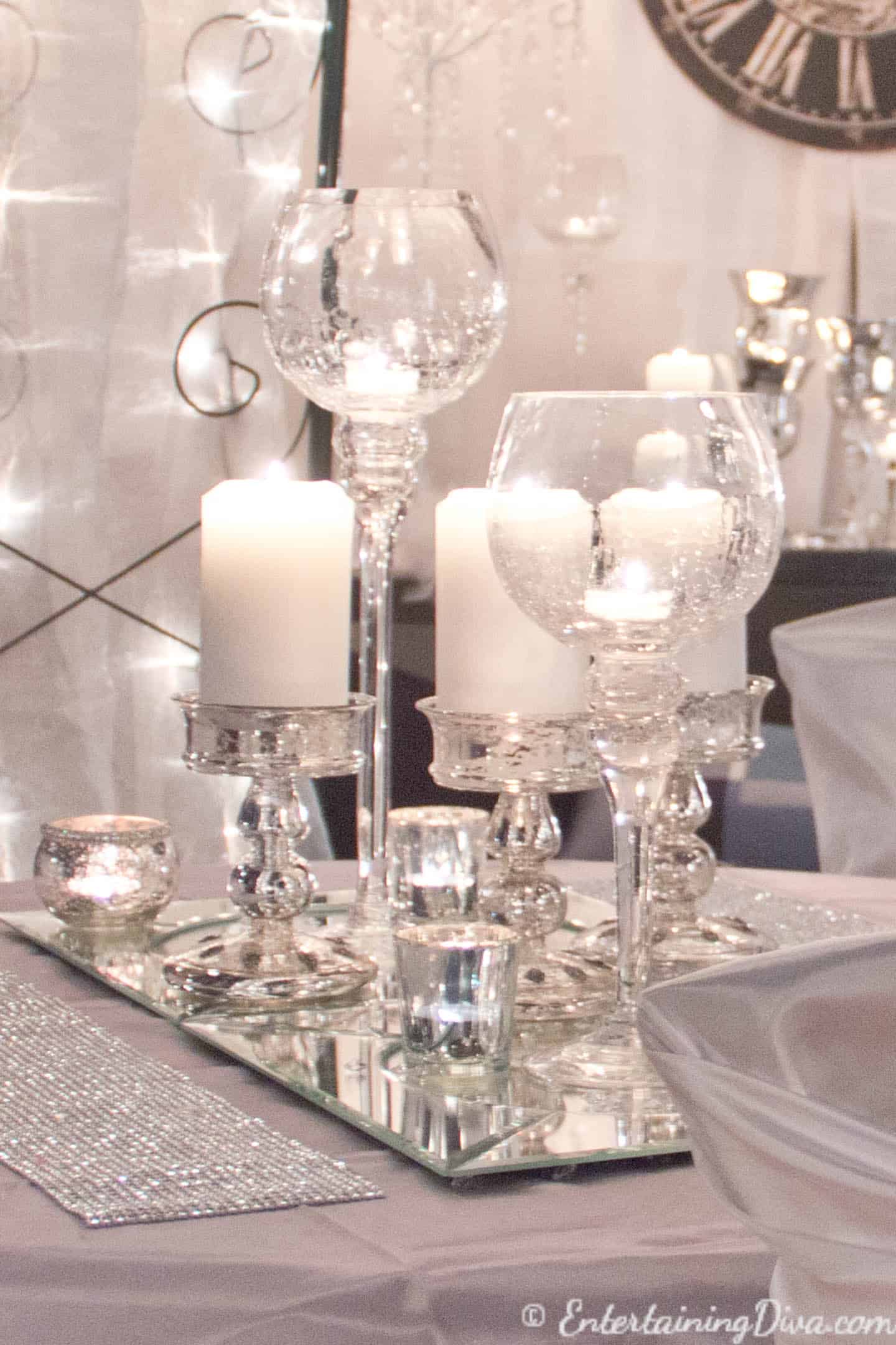 White candles on mirror chargers as a last minute New Year's Eve Party decoration on a table