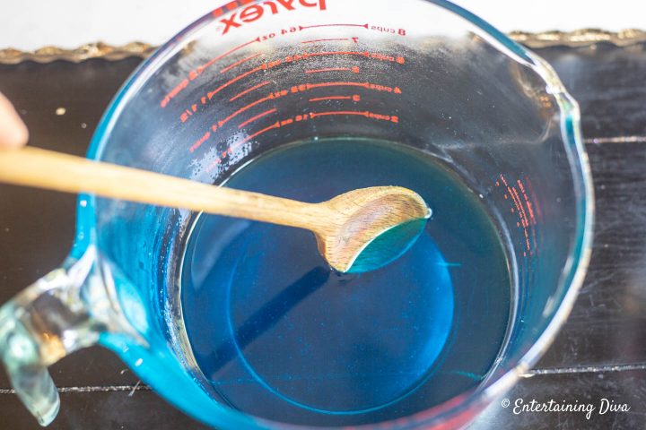 Berry blue jello and hot water being mixed for jello shots