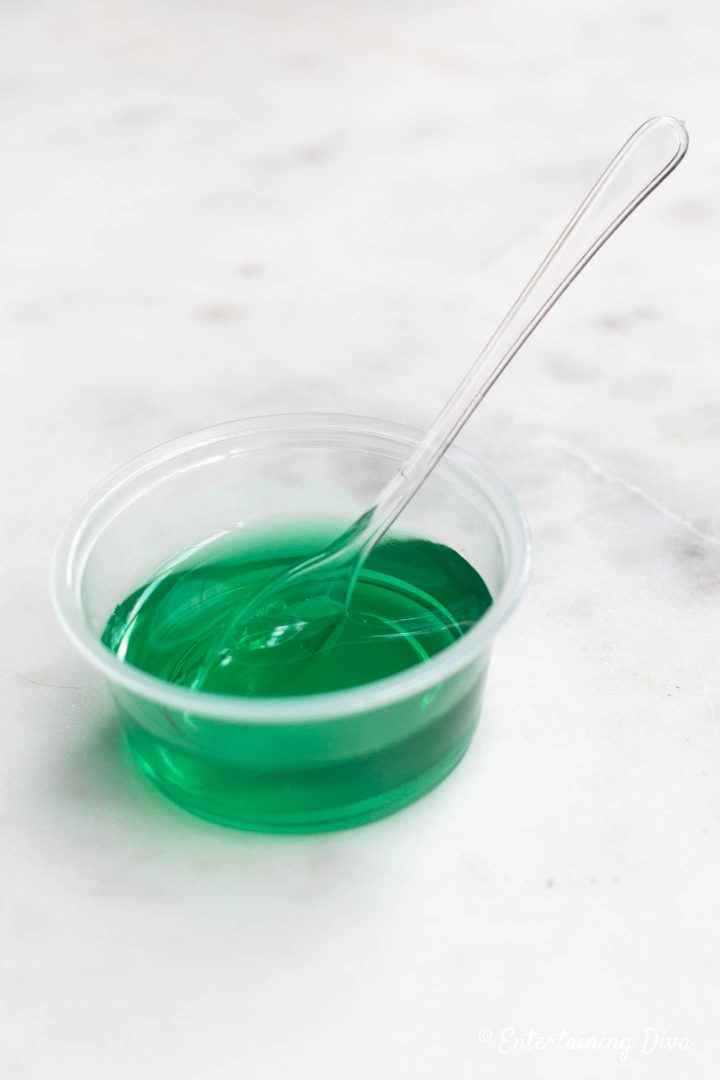 Blue Curacao Margarita jello shot in a jello shot cup with a tasting spoon
