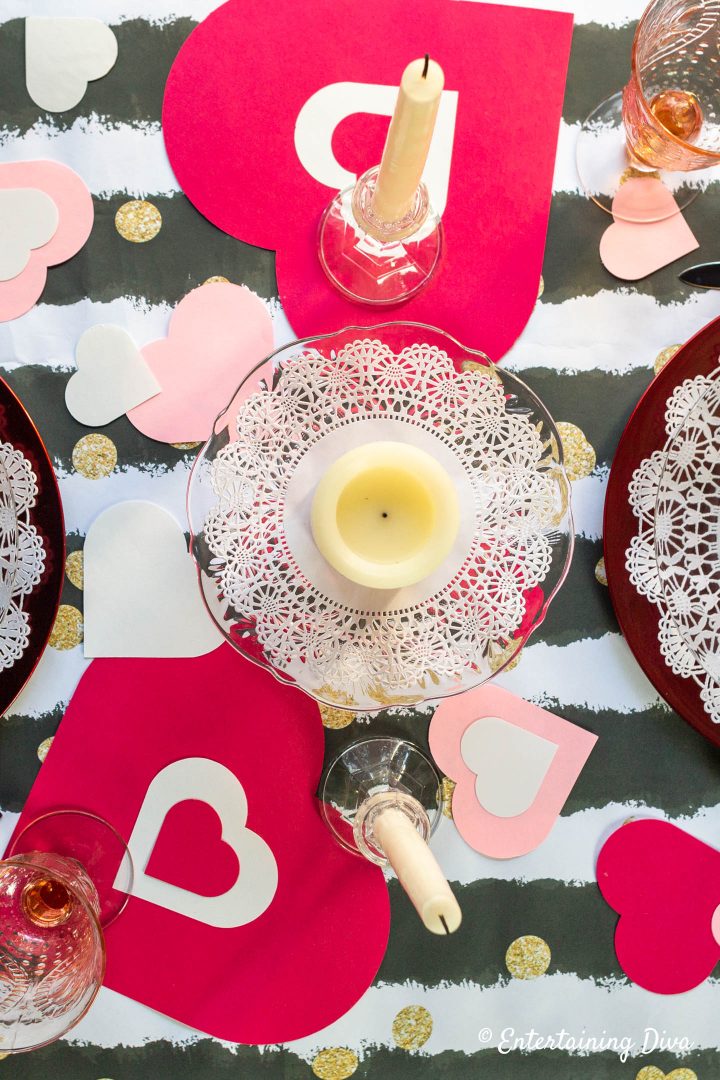 Red, white and pink hearts with white candles as a Valentine table centerpiece