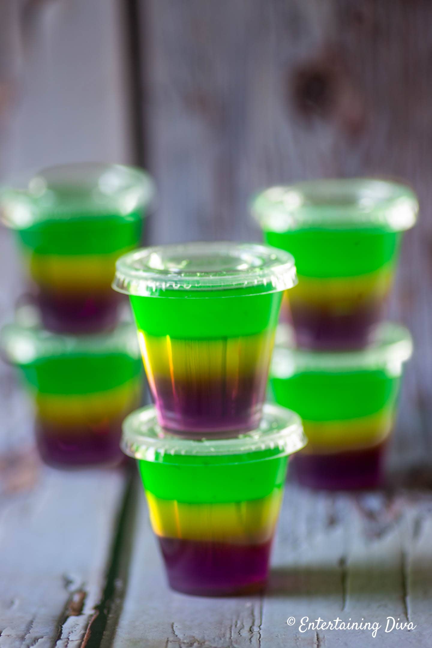 Stacks of Mardi Gras Jello shots on a gray background