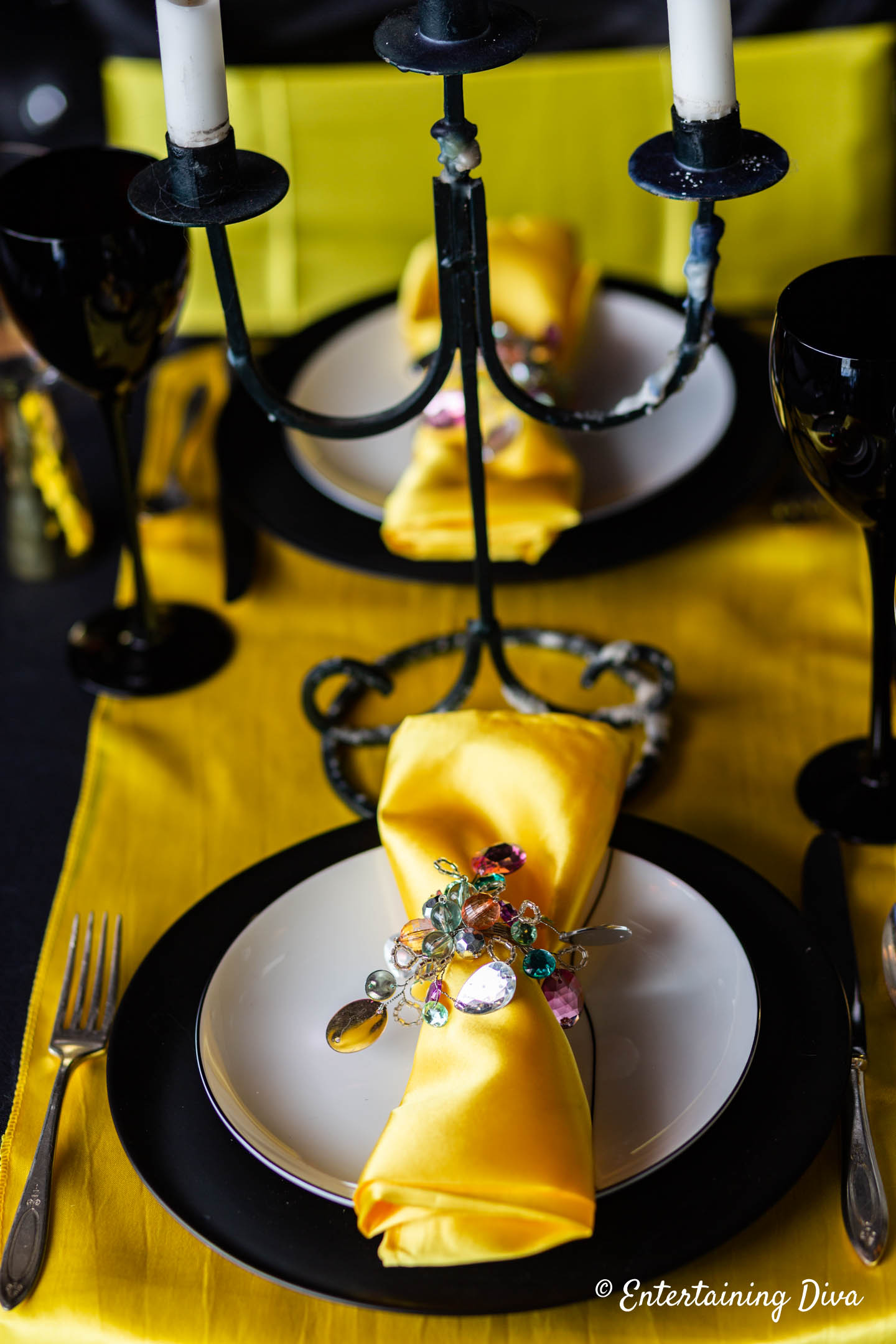 Hufflepuff House place setting with a yellow napkin and table runner and black and white plates