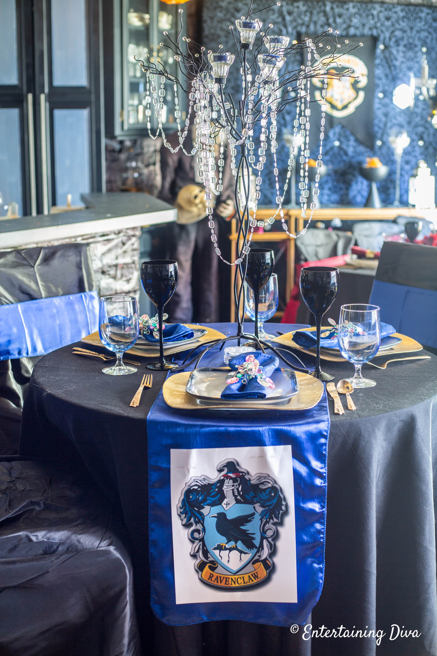 Blue and gold table decorations with a Slytherin crest on a blue table runner