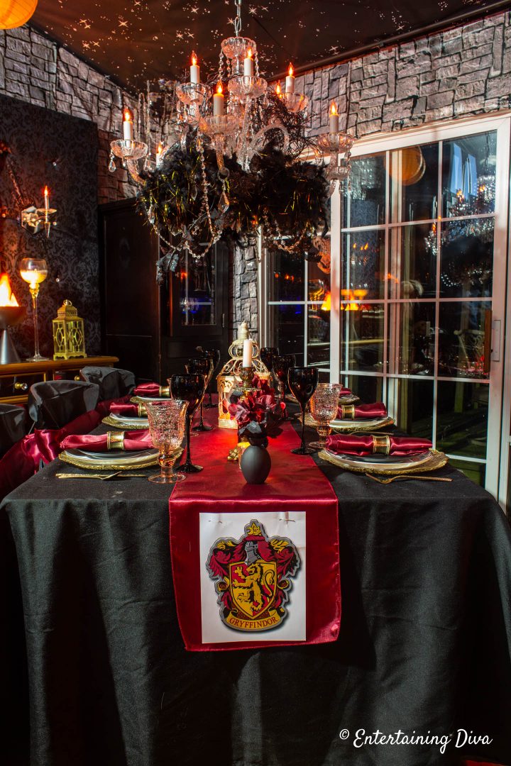 Red, gold and black Gryffindor tablescape with the Gryffindor crest pinned to the table runner