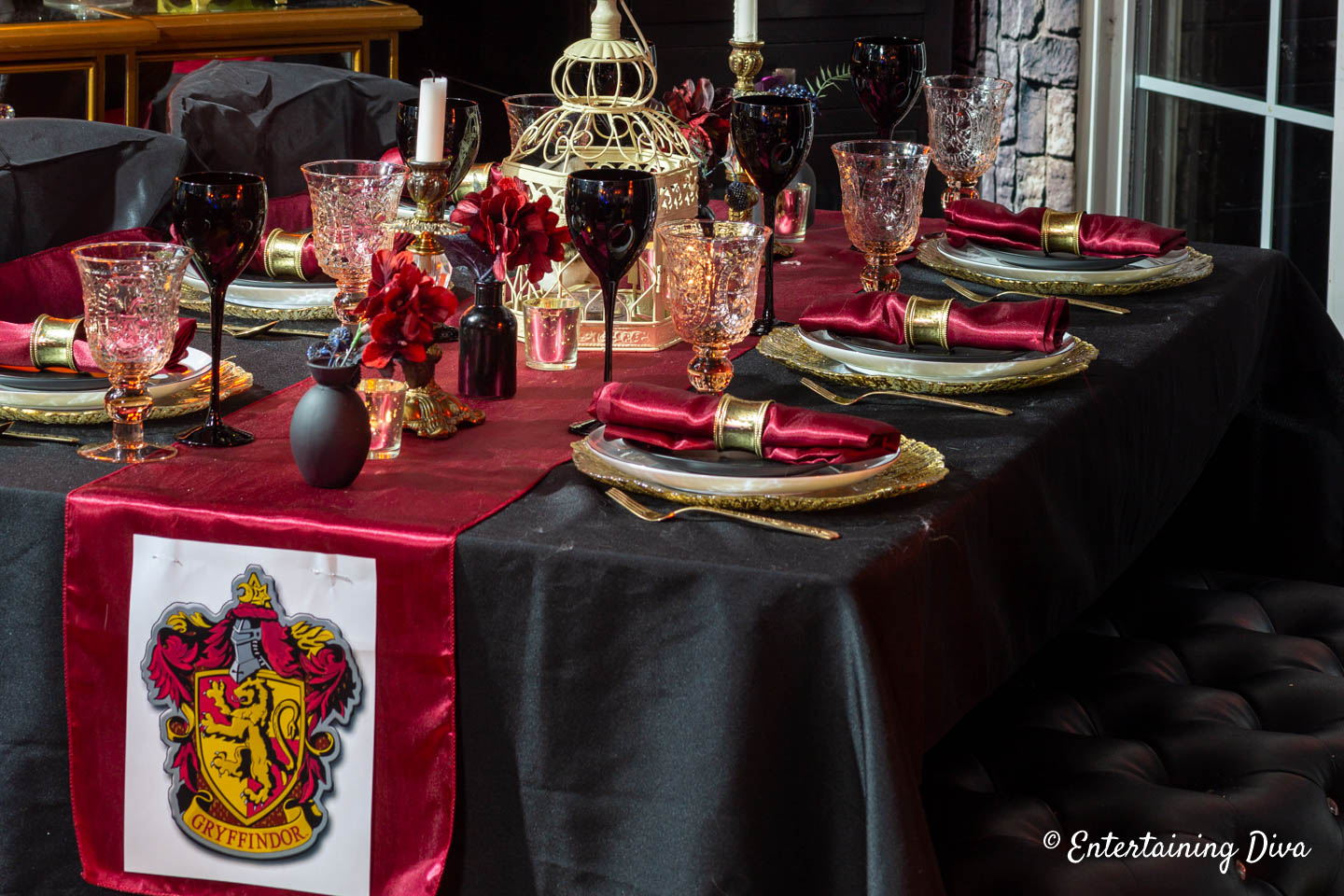 Harry Potter table decor for Gryffindor house using red table runner and napkins with a black tablecloth and black wine glasses