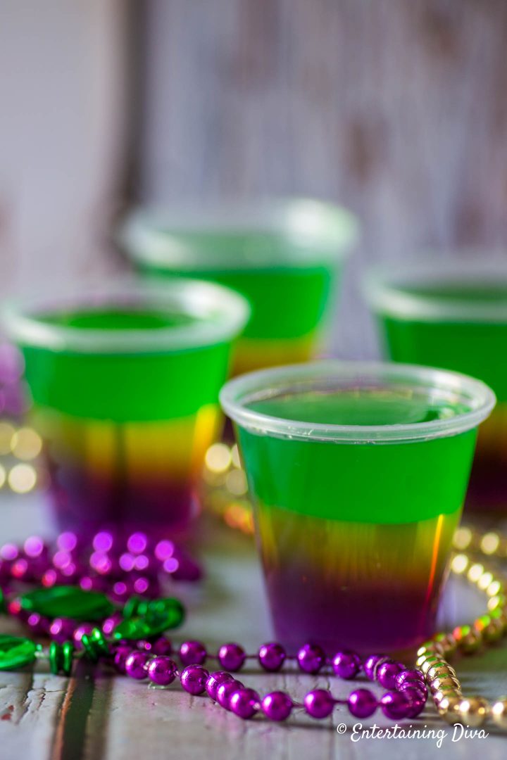 Layered Mardi Gras jello shots with Mardi Gras beads