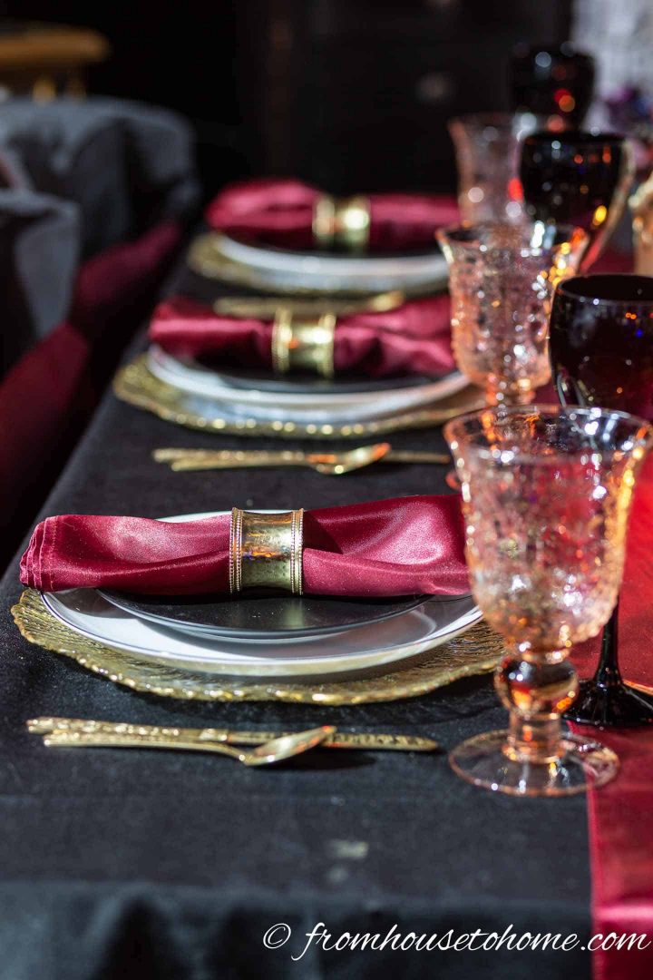 Black, gold and red table setting with pink water glasses and black wine glasses